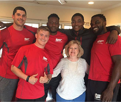 A happy customer stands for a photo with her team of willing Atlanta movers!