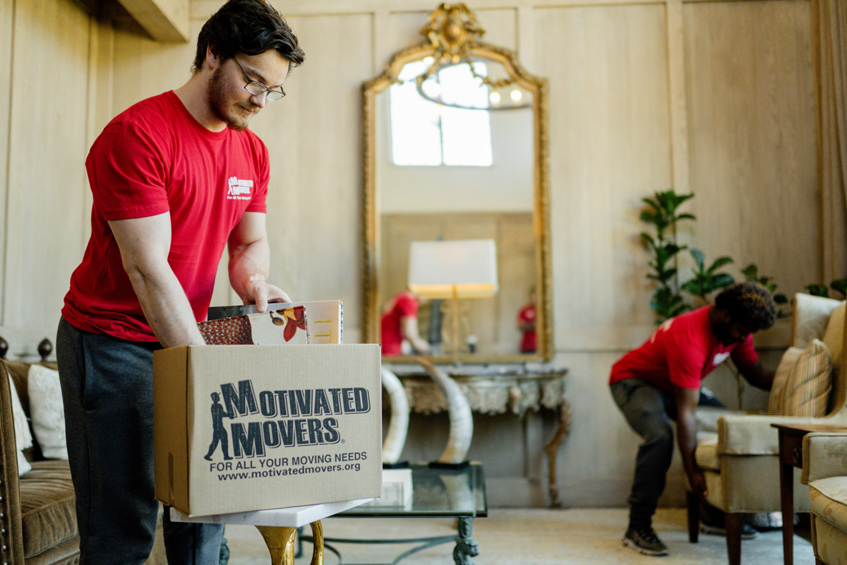 Motivated Movers Birmingham team working away packing up items in house.